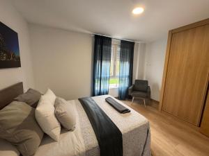 a bedroom with a bed and a chair in it at LUGO Stay in Lugo