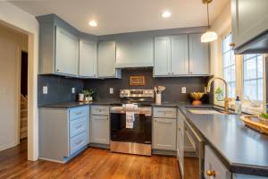 a kitchen with white cabinets and stainless steel appliances at Eden at Blue Lane in Olathe