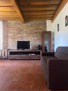 a living room with a tv and a brick wall at Apartments Mali Raj in Dolenci