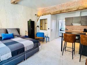 a bedroom with a bed and a desk and a kitchen at DinLoft in Dinant