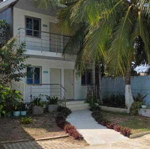 a white building with palm trees in front of it at Aquitania in Rincón