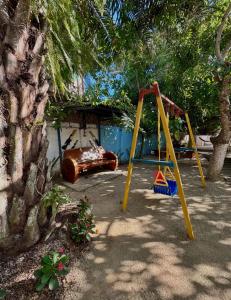 a playground with a swing set and a tree at Aquitania in Rincón