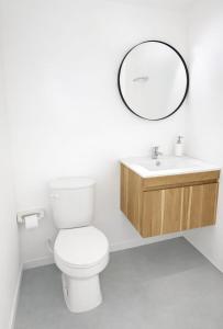 a bathroom with a toilet and a sink and a mirror at Aquitania in Rincón