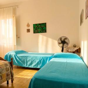 a hospital room with two beds and a fan at Casa Aloe by My Home Apulia in Torre Lapillo