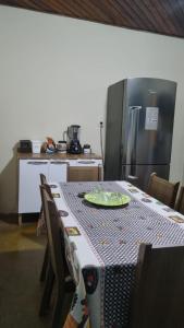 a kitchen with a table and a refrigerator at Casas oliveira in Paraty