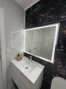 a bathroom with a white sink and a mirror at Ocean Palm Apartments II - Edifício Paradis- Cidadela in Praia +32 photos