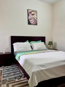 a bedroom with a large bed with a picture on the wall at Synacassi 2 in Abidjan