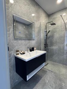 a bathroom with a sink and a shower at Sorelle Hotel in Prizren