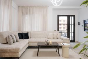 a living room with a couch and a table at Poolside and Garden Apartments Golem Beach in Golem