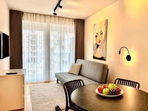 a living room with a table and a couch at M2Suites by BestChoice - Messe - Parking - Self-Check-in in Graz