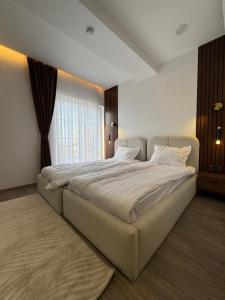 a large bed in a room with a large window at Sorelle Hotel in Prizren