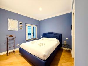 a bedroom with a large bed with blue walls at La Casa Del Pittore - Centro Storico in Legnano