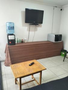 ein Wohnzimmer mit Fernseher und Couchtisch in der Unterkunft Hotel Morelia Nova in Morelia