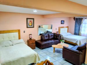 a hotel room with two beds and a couch at BONITO y AMPLIO DEPARTAMENTO con JARDÍN "EL PARAÍSO DE ZACATLÁN" in Zacatlán