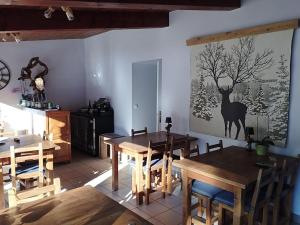 a dining room with wooden tables and a deer picture on the wall at O Clarée in Val-des-Prés