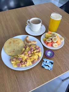 a table with two plates of food and a cup of beer at Hotel Exelsior in Cúcuta