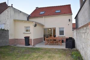 a house with a patio with a wooden table at brise marine in Le Crotoy