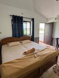 a bedroom with a large bed with a bottle on it at Paulina's Guest House in Madgaon