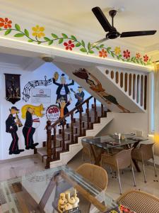 a dining room with a mural on the wall at Paulina's Guest House in Madgaon