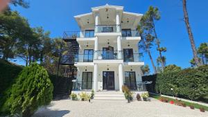 a large white building with aventh floor at Poolside and Garden Apartments Golem Beach in Golem