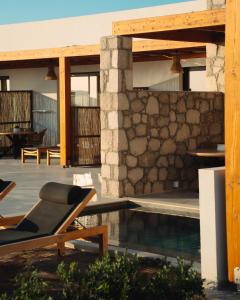 a house with a swimming pool and a patio at Obsidian Suites Milos in Mytakas