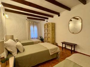 a bedroom with two beds and a mirror at Casa Rural La Font in Sant Mateu