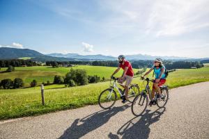 a man and a woman riding bikes down a road at Ferienwohnung Sam in Laimgrub