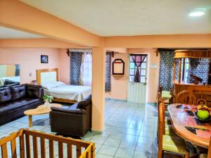 a living room with a bed and a dining room at El paraíso de Zacatlán DEPARTAMENTO con JARDÍN y Lumbrera, 11 personas in Zacatlán