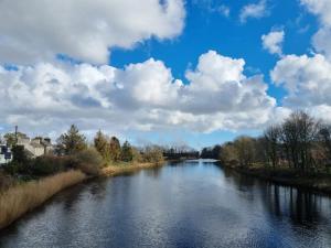 a river with a blue sky and clouds at ABC Bladnoch in Newton Stewart