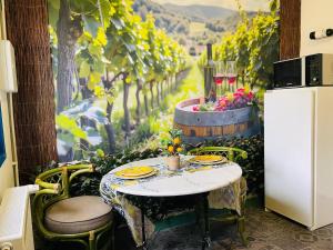 a table with yellow plates on it next to a vineyard at Nature, évasion, jacuzzi, grande piscine et cinéma in Houdancourt