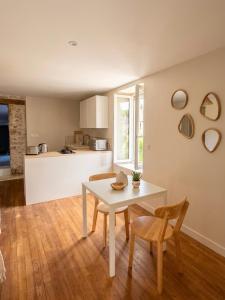 a kitchen and dining room with a white table and chairs at Oasis proche du Futuroscope in Saint-Cyr +9 photos