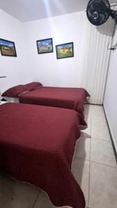 two beds in a room with red sheets at Apto Rincón del Café -"Piscina-Parking-8min Parque Café 321-435-21-00" in Montenegro