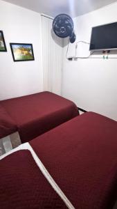 two beds in a room with red sheets at Apto Rincón del Café -"Piscina-Parking-8min Parque Café 321-435-21-00" in Montenegro