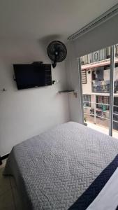a bedroom with a bed and a television on the wall at Apto Rincón del Café -"Piscina-Parking-8min Parque Café 321-435-21-00" in Montenegro +20 photos