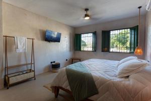a bedroom with a bed and two windows at Casa Calma 45 in Mérida +20 photos