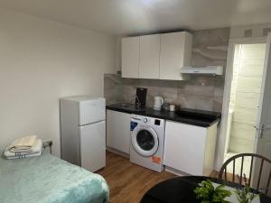 a kitchen with a washing machine and a refrigerator at Studio near Addenbrookes and Centre By Miller Residence in Cherry Hinton