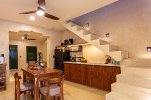 a kitchen with a dining table and a staircase at Casa Calma 45 in Mérida