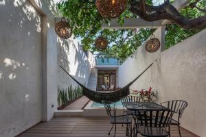 a hammock on a patio with a table and chairs at Casa Calma 45 in Mérida