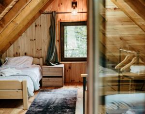 a bedroom with a bed in a wooden cabin at Mountain rest Brezna in Plužine