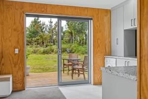 a kitchen with a sliding glass door leading to a patio at The Little Hive in Westport +10 photos