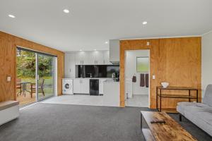 a living room with a couch and a kitchen at The Little Hive in Westport