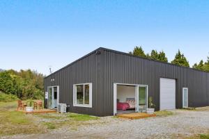 a black building with a bedroom in it at The Little Hive in Westport