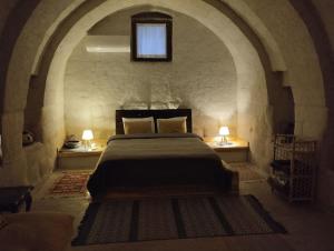 a bedroom with a large bed in a stone room at Route Cappadocia in Avanos