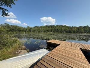 a dock on a lake with trees in the background at The Beaver Den in Haliburton