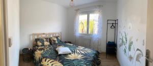 a bedroom with a bed with a comforter and a window at Le rendez-vous des 2 amants in Romilly-sur-Andelle