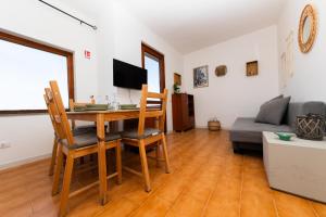 a living room with a table and chairs and a couch at L14 Appartamento Valle della Luna in Stintino