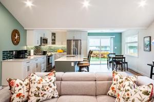 a living room with a couch and a kitchen at Harbourview Hideaway Sooke in Sooke