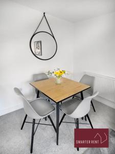 a dining room table with two chairs and a mirror at High Wycombe - Garden Parking 2Bed in Buckinghamshire