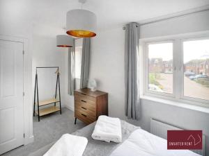 a bedroom with a bed and a window and a dresser at High Wycombe - Garden Parking 2Bed in Buckinghamshire