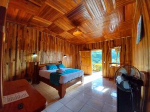 a bedroom with a bed and a wooden ceiling at Belcruz family lodge in Monteverde Costa Rica